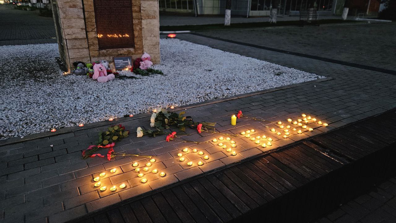 Жители района несут цветы к стелле Андрея Первозванного в память о жертвах теракта